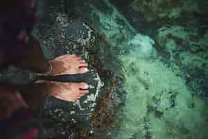 Free photo creative shot of a male with his feet in the water in  st maarten, the caribbean