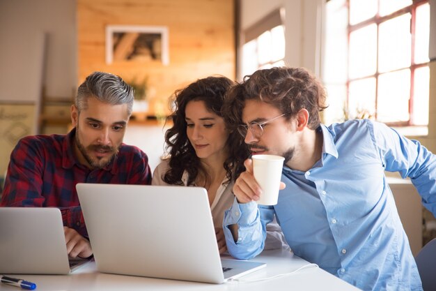 Creative team watching project presentation on laptop