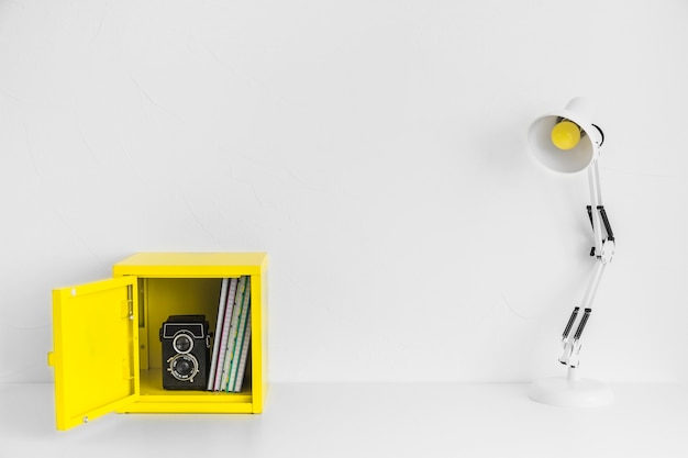 Творческое рабочее место в белом и желтом цветах с коробкой и старой камерой