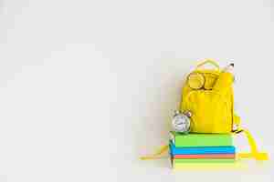 Бесплатное фото Творческое рабочее пространство с желтым рюкзаком и ноутбуками