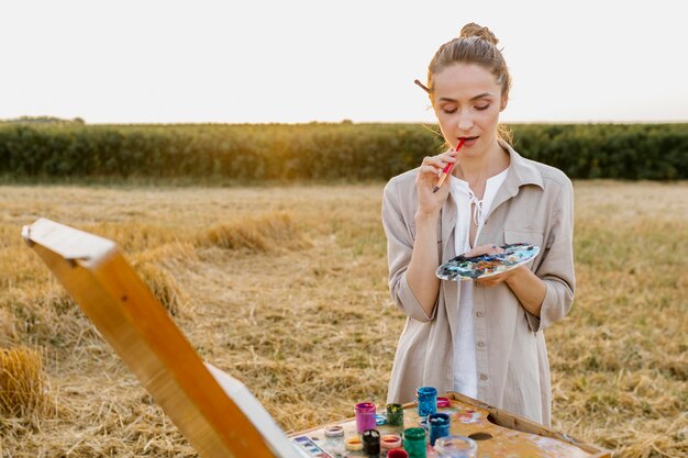 Creative young woman hand painting in the nature