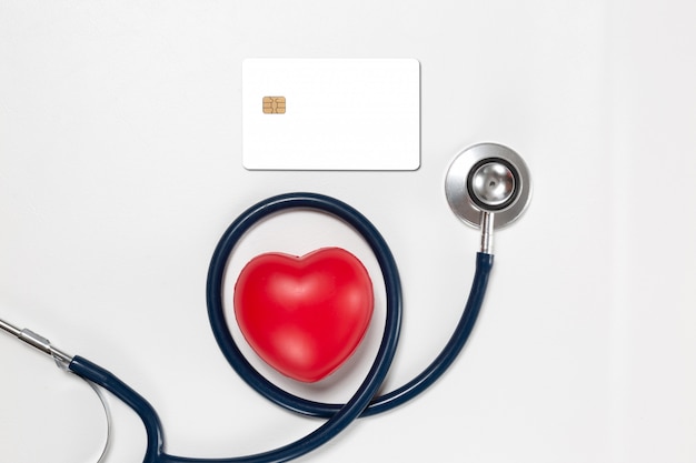 кредитная карта и стетоскоп с красным сердцем