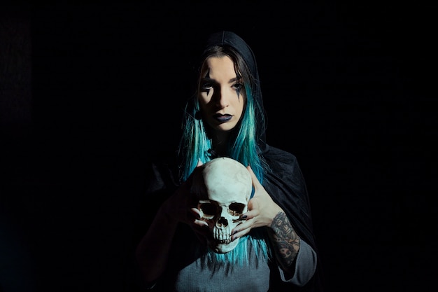 Creepy enchantress holding skull