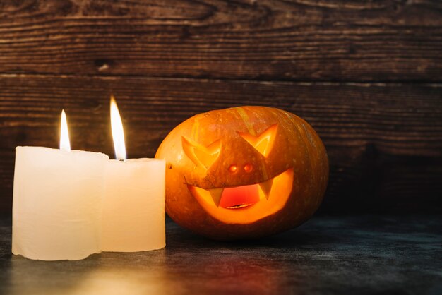 Creepy illuminating Halloween pumpkin and candles