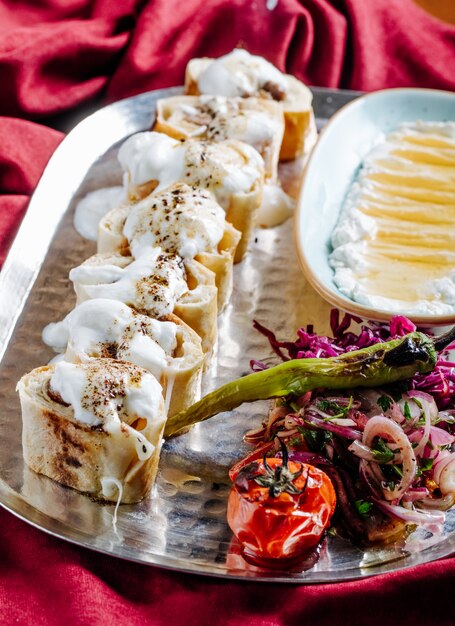 Crepes stuffed with food and cream sauce on the top with grilled food.