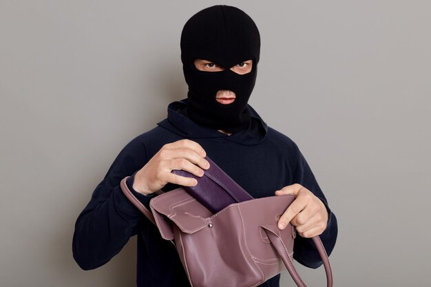 도둑이 훔친 가방에서 지갑을 꺼냅니다.