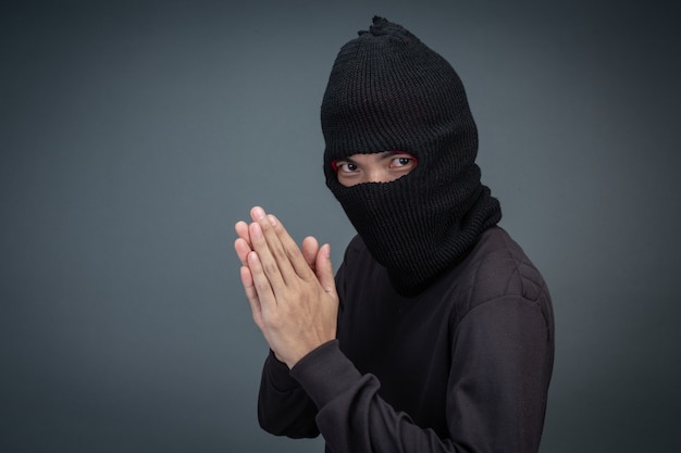 Бесплатное фото Преступники носят маску черного цвета на сером