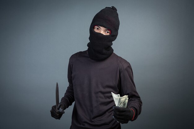 Free photo criminals wear black mask and hold dark on gray