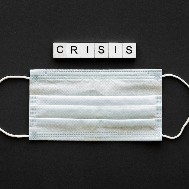 Crisis word written on wooden cubes with medical mask