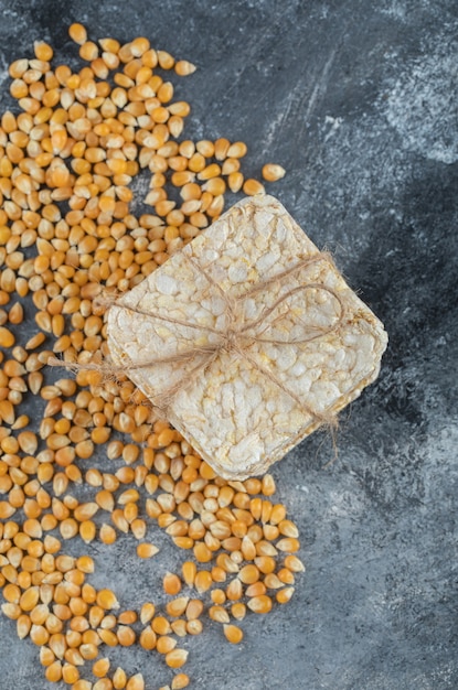 Crisp bread in rope with uncooked popcorn seeds.