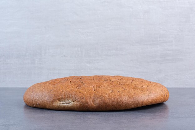 대리석 바탕에 빵 한 덩어리의 선명한 라운드. 고품질 사진
