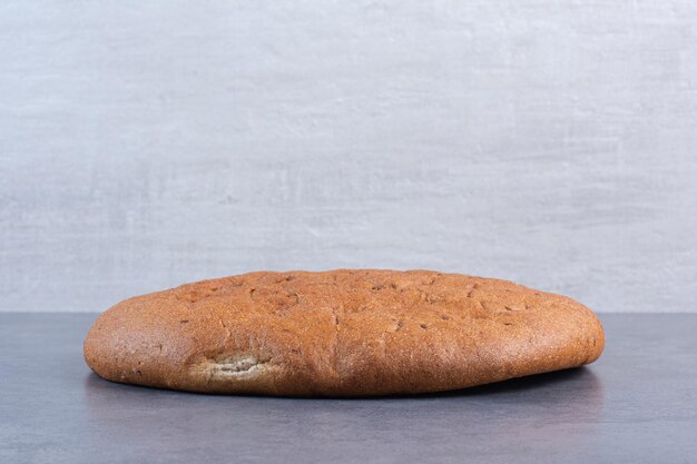 Crisp round loaf of bread on marble background. High quality photo