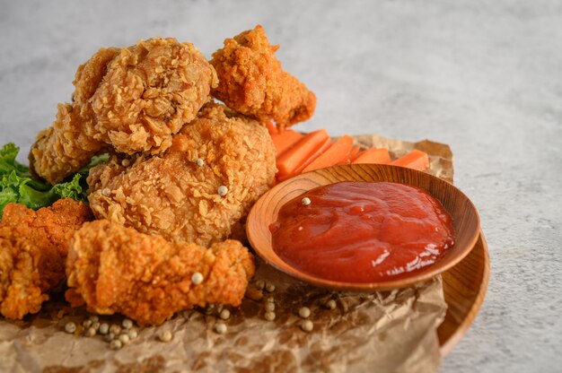 Crispy fried chicken on a plate with tomato sauce