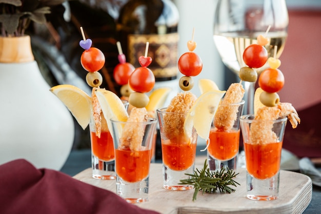 Crispy fried shrimps served in shot glasses with sweet chili sauce and lemon