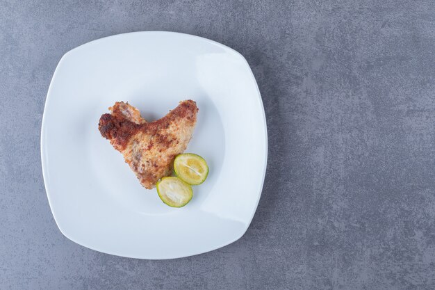 Crispy fried wing on white plate.