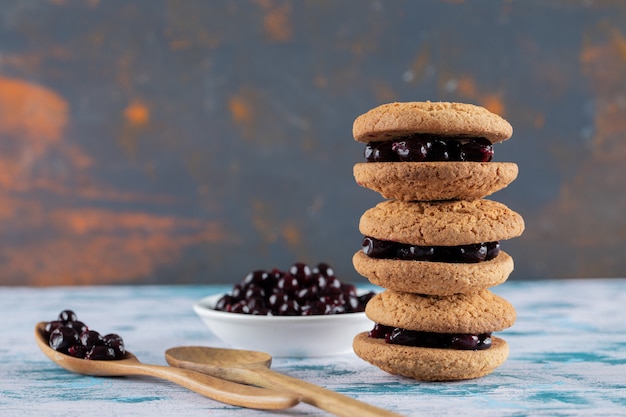 Free photo crispy oatmeal cookies with blackcurrant berry confiture on it