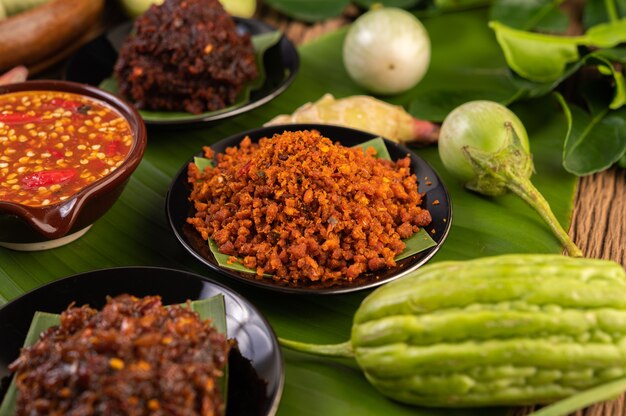 Free photo crispy pork chili paste on banana leaves in a plate with side dishes.