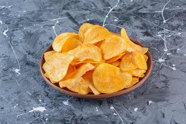 Free photo crispy potato chips in plate , on the marble surface