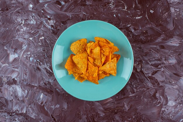 Crispy spicy chips on a plate , on the marble table. 