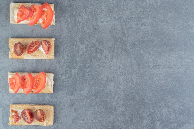 Foto gratuita toast croccanti con pomodori su marmo.