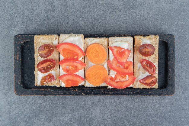 Хрустящие тосты с помидорами на деревянной доске.