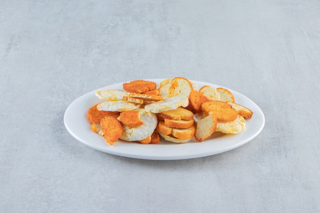 Crispy wholegrain rice cakes and crackers on white plate.