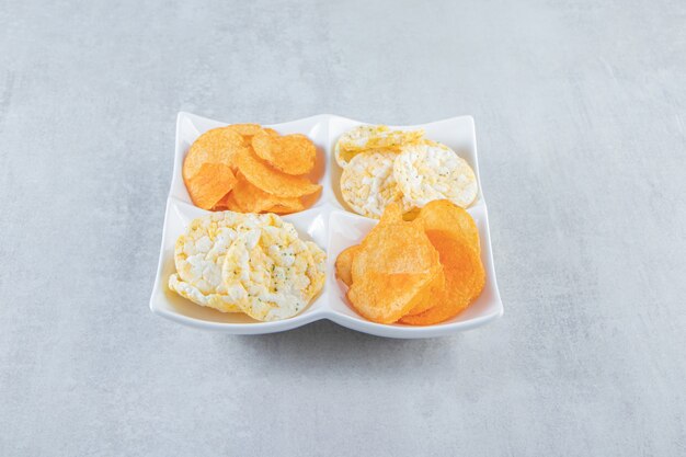 Crispy wholegrain rice cakes and spicy chips in white bowls.