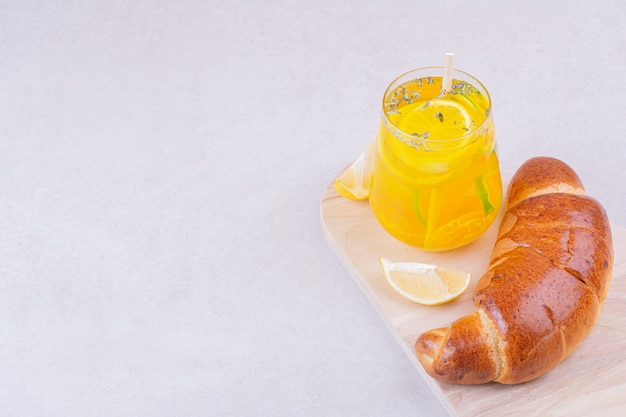 Free photo croissant bun with a glass of lemonade