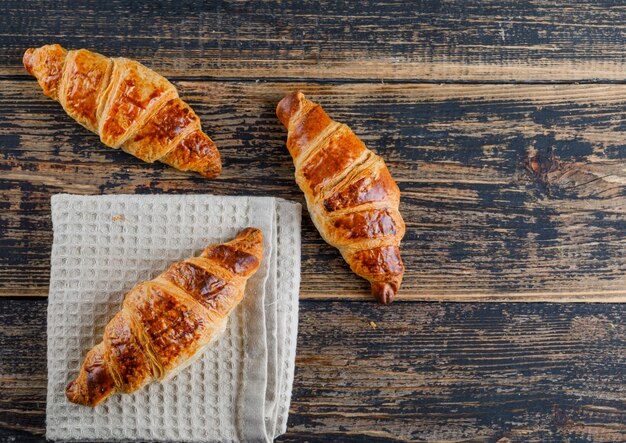 Croissant flat lay on wooden and kitchen towel
