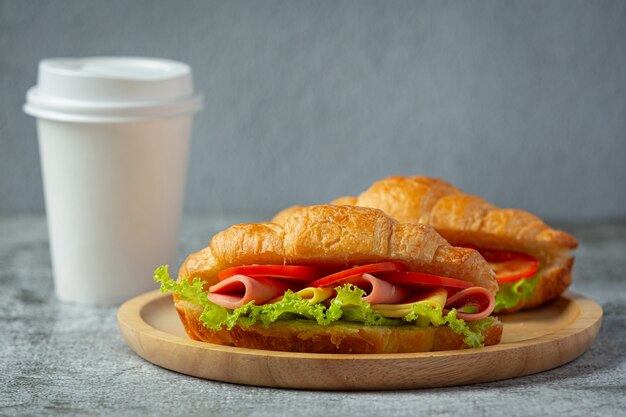 Croissant sandwiches on dark wooden surface