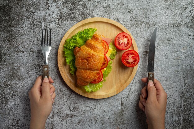 Croissant sandwiches on dark wooden surface