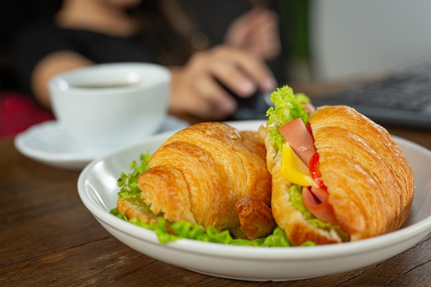 Croissant sandwiches on dark wooden surface