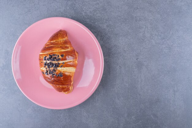 Croissant with chocolate on a plate , on the marble.