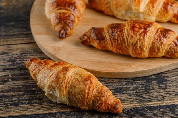 Croissant on wooden and cutting board, close-up.