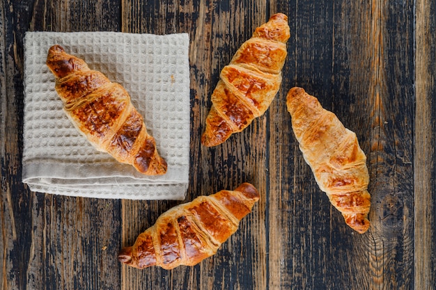 Croissant on wooden and kitchen towel. flat lay.