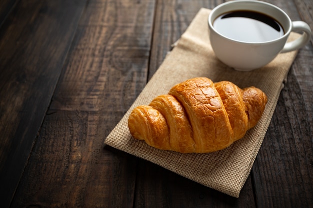 croissants and coffee on old wood table.