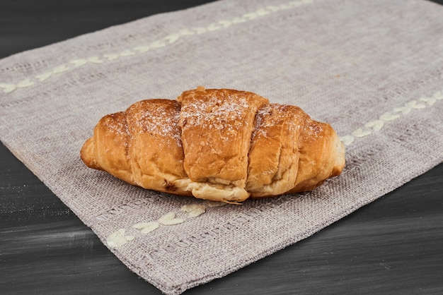 Foto gratuita croissant su un canovaccio grigio.