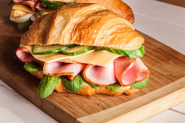 Croissants sandwiches on the wooden cutting board