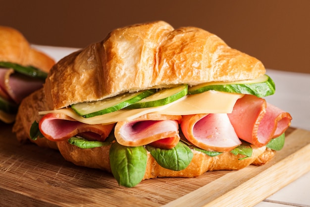 Croissants sandwiches on the wooden cutting board