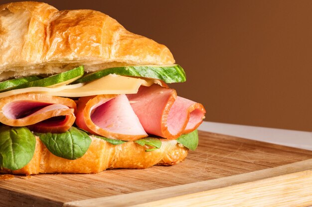 Croissants sandwiches on the wooden cutting board