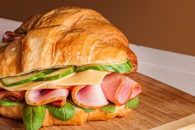 Croissants sandwiches on the wooden cutting board