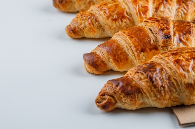 Croissants on white and paper bag, close-up.