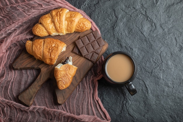 Croissants with chocolate filling on a wooden board . 