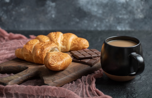 Croissants with chocolate filling on a wooden board . 
