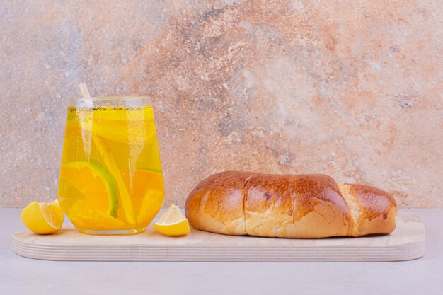 Croissants with a glass of lemonade on white surface