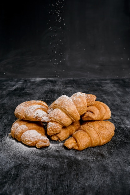 Cornetti con zucchero a velo sul tavolo grigio.