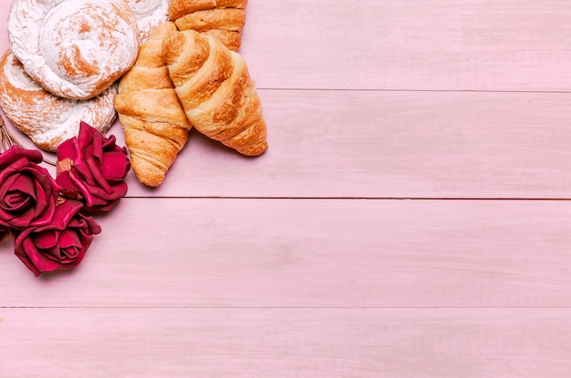 Free photo croissants with red roses buds and buns