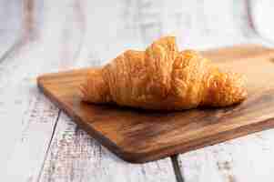 Foto gratuita croissant su un tagliere di legno.