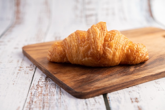 Croissants on a wooden cutting board.