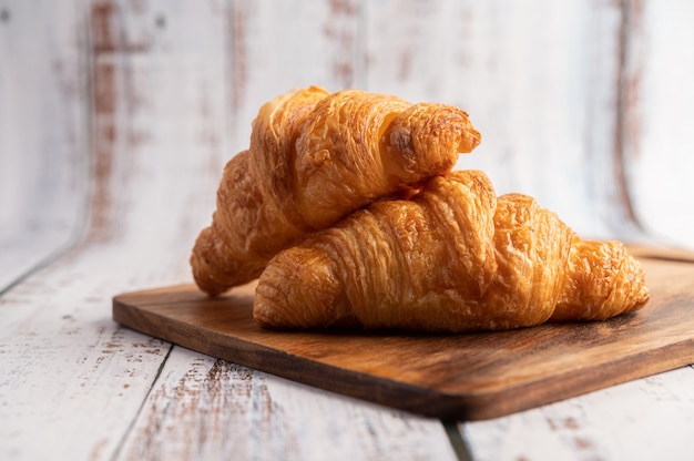 Croissants on a wooden cutting board.